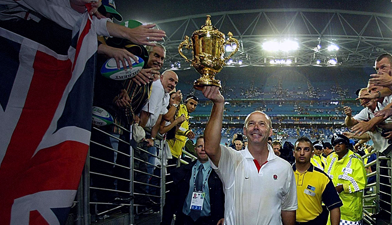 Clive holding the rugby world cup in the air to show the fans.